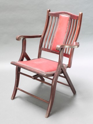 An Edwardian mahogany folding campaign open arm chair, the seat and back upholstered in rexine 