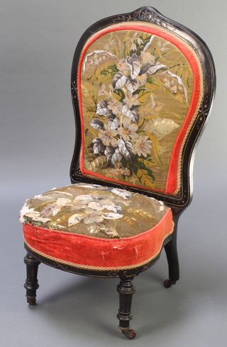 A Victorian carved and ebonised nursing chair, the seat and back upholstered in beadwork, on turned and fluted supports 