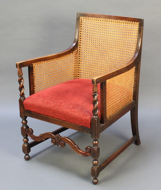 A beech framed single cane bergere library chair with upholstered seat and shaped stretcher, raised on turned and block supports 