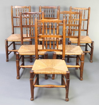 A set of 6 elm spindle back dining chairs with woven rush seats, raised on club supports