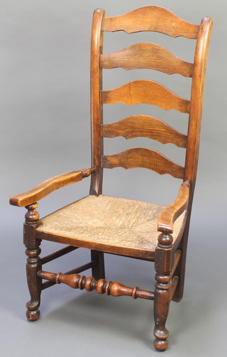 An elm ladder back open arm chair with woven rush seat