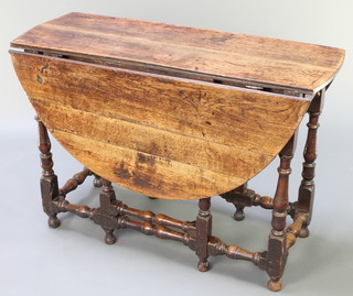 A 17th/18th Century oak oval drop flap gateleg dining table fitted a drawer and raised on turned supports 29 1/2"h x 43 1/2"w x 15" when closed x 49" when open