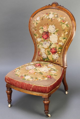 A Victorian inlaid and figured walnut show frame nursing chair with carved cresting rail, the seat and back upholstered in Berlin woolwork 