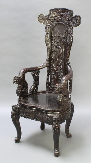 An Oriental carved ebonised hardwood tub back chair with dragon arms, raised on cabriole supports 
