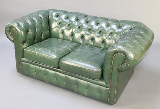 A 2 seat Chesterfield settee upholstered in green buttoned leather 25"h x 60"w x 35"d 