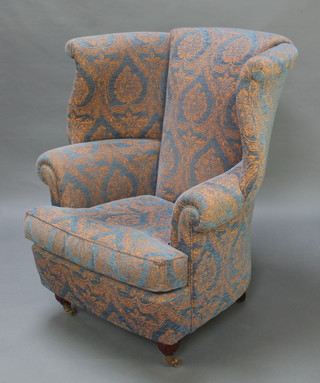 A Georgian style wing tub back armchair upholstered in blue material 