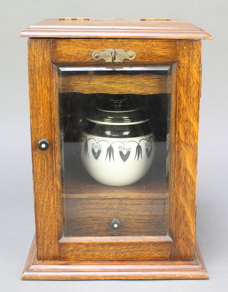 A 1930's oak smoker's cabinet fitted a pottery tobacco jar and enclosed by a bevelled panelled door 11" x 8" x 7", a gift to Alfred Chumbley Neale former chief clerk at Reading Crown Court with press cutting mentioning the gift