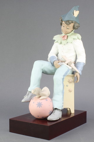 A Lladro figure of a seated boy with a puppy sitting on a ball, 13703, 61/500, with certificate, boxed, 15 1/2" 
