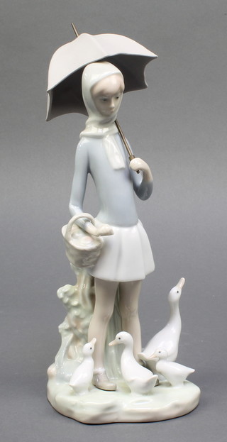 A Lladro figure of  a girl with umbrella, basket and geese 10", boxed