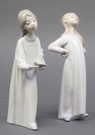 A Lladro figure of a child in a night dress 8" boxed, a ditto of a child holding a chamber stick 8" boxed