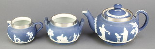 A Wedgwood blue Jasperware tea set comprising teapot, milk jug and sugar basin with silver rims