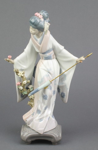 A Lladro figure of a Japanese lady with flower in one hand and a parasol in the other, raised on a scroll base 11" 