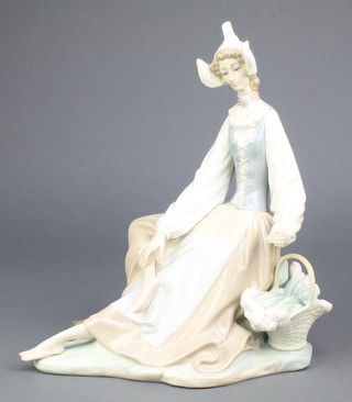 A Lladro figure of a seated lady with a basket of flowers at her side 10 1/2" 