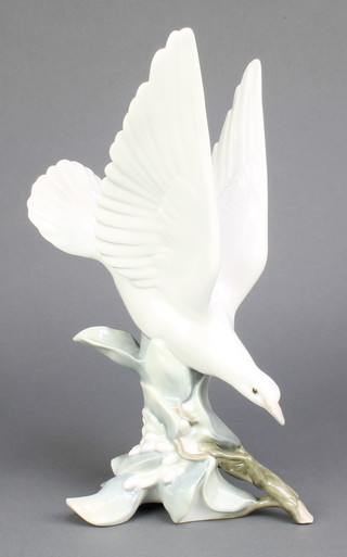 A Lladro figure of a bird standing on a branch 10" 