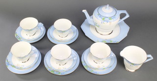 An Art Deco Paragon tea service with blue borders decorated with flowers comprising teapot, milk jug, sandwich plate, 5 small plates, 5 tea cups and 5 saucers 