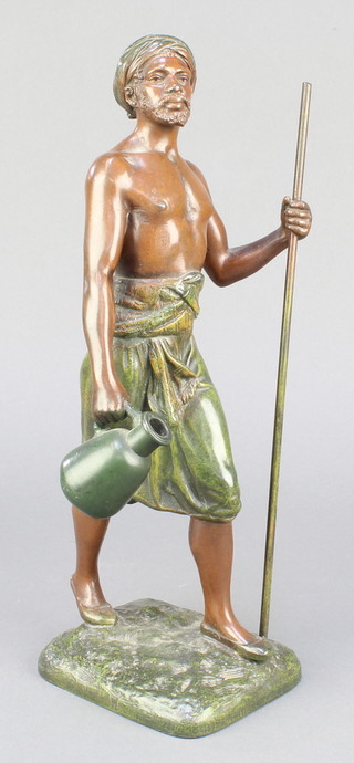 After Marcel Debut, a cold painted spelter figure of a water carrier with staff, raised on square base 12" 