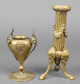 A 19th Century reeded gilt ormolu candlestick with swag decoration, raised on 3 out swept paw feet 7" and a 19th Century gilt metal Roman style twin handled urn, raised on a circular spreading foot  5" 