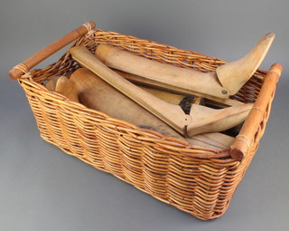 A rectangular wicker basket containing a collection of various beech part boot trees 