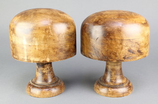 2 turned wooden hat forms, raised on socle bases 9" 