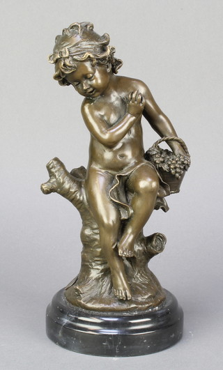 A bronze figure of a seated cherub with basket of grapes raised on a marble socle base 9" 