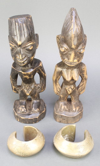 A pair of Ebeji carved wooden figures 11" together with a pair of African money bangles
