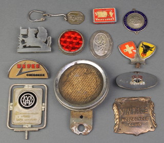 A metal tax disc holder, a square bronzed metal vintage Motorcycle Club plaque 2" x 2" and other minor car badges 