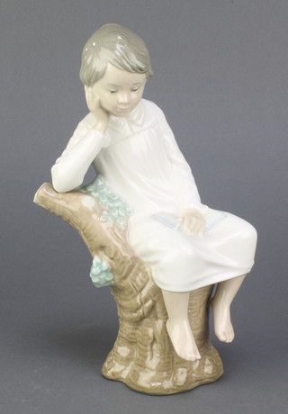 A Lladro figure of a child sitting on a tree stump A/125 8", boxed