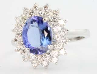 An 18ct white gold tanzanite and diamond oval cluster ring, the centre stone 2.17ct surrounded by 16 brilliant cut diamonds 0.96ct, size M