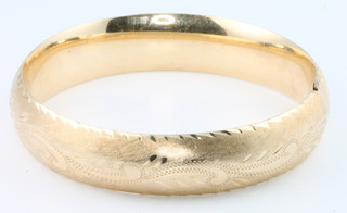 A 14ct yellow gold chased hollow bangle, 22 grams
