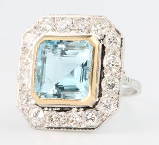 An 18ct white gold aquamarine and diamond cluster ring, the square cut centre stone approx. 6.5ct surrounded by 16 brilliant cut diamonds approx. 1.8ct, size N 1/2