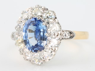 An 18ct yellow gold sapphire and diamond oval cluster ring, the centre stone approx. 2.2ct, surrounded by brilliant cut diamonds approx. 1.3ct, size O 1/2