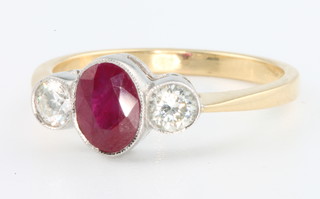 An 18ct yellow gold ruby and diamond 3 stone ring, the oval centre stone approx 0.95ct flanked by 2 diamonds 0.4ct, size O 