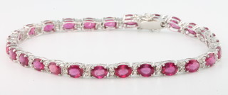 An 18ct white gold ruby and diamond line bracelet, rubies approx. 14.45ct, diamonds approx. 0.41ct