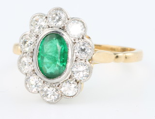 An 18ct yellow gold emerald and diamond oval ring, the centre stone approx. 0.8ct surrounded by 10 brilliant cut diamonds 0.75ct 