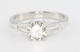 An 18ct white gold diamond ring, the centre brilliant cut stone 0.96ct flanked by 2 tapered baguette stones 0.27ct, size M 