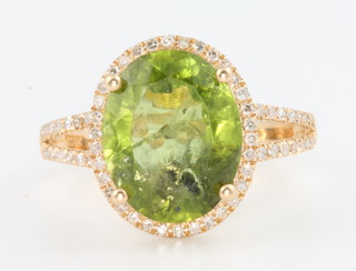 A 14ct yellow gold peridot and diamond ring, the centre stone approx. 5.7ct surrounded by brilliant cut diamonds with an open diamond set shank, size N