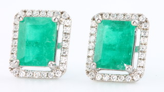 A pair of 18ct white gold emerald (4.81ct) and diamond (0.60ct) rectangular earrings