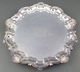 A silver salver with fancy scroll and shell rim and presentation inscription Birmingham 1933, 910 grams 