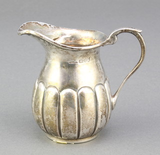 An Edwardian silver cream jug with demi-fluted decoration Chester 1903, 64 grams 3" 