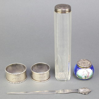A silver paper knife with scroll grip Birmingham 1971, a silver mounted toilet jar, 2 napkin rings and a porcelain scent bottle with silver lid 
