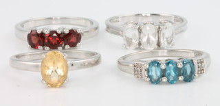 4 silver gem set rings, citrine, topaz, garnet and blue topaz, size N 1/2 