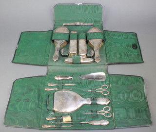 A silver brush set comprising comb, 2 hair brushes, 2 clothes brushes, a nail buffer, 2 pots, a shoe horn, 3 piece manicure set, button hook, hand mirror, 2 pairs of scissors and a brush contained in a leatherette case Birmingham 1912/1913
