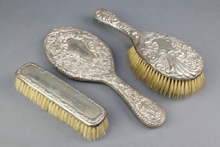 A Victorian silver repousse hair brush Birmingham 1898, a similar hand mirror and clothes brush