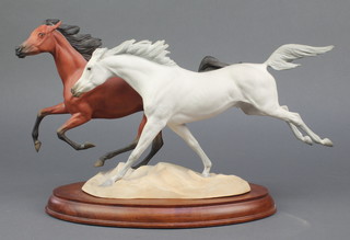 A Franklin Mint porcelain group of 2 running horses on a wooden base 18"  