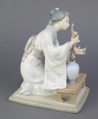 A Lladro figure of a seated Japanese lady arranging flowers in a vase 8 1/2", boxed