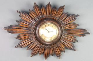 An Art Deco Smiths wall clock with gilt chapter ring and Roman numerals, contained in a carved oak sunburst case 