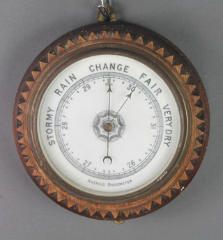 An aneroid barometer contained in a carved oak case