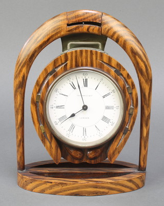 A Victorian 8 day timepiece with paper dial and Arabic numerals contained in a carved oak case in the form of a stirrup and horse shoe, the dial marked Thornton Hill & Co London 