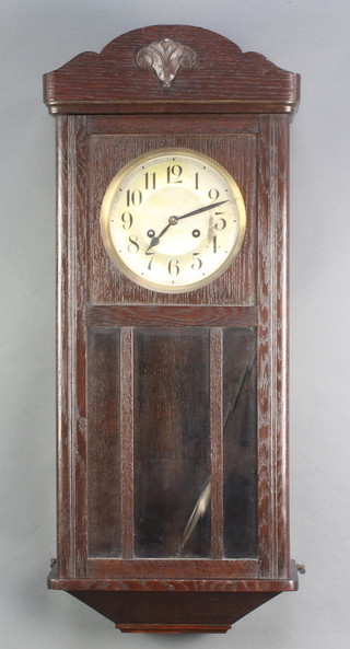 A 1930's 8 day striking wall clock with silvered dial contained in an oak case 