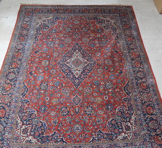A brown and blue ground Kashan rug with central medallion 175" x 125", in wear 